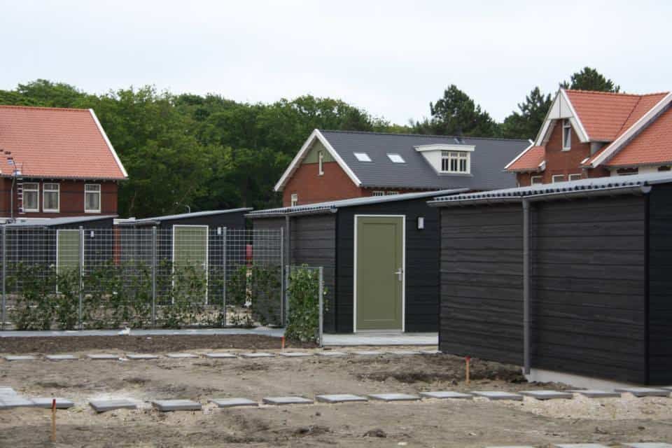 Zwarte bergingen met groene deur