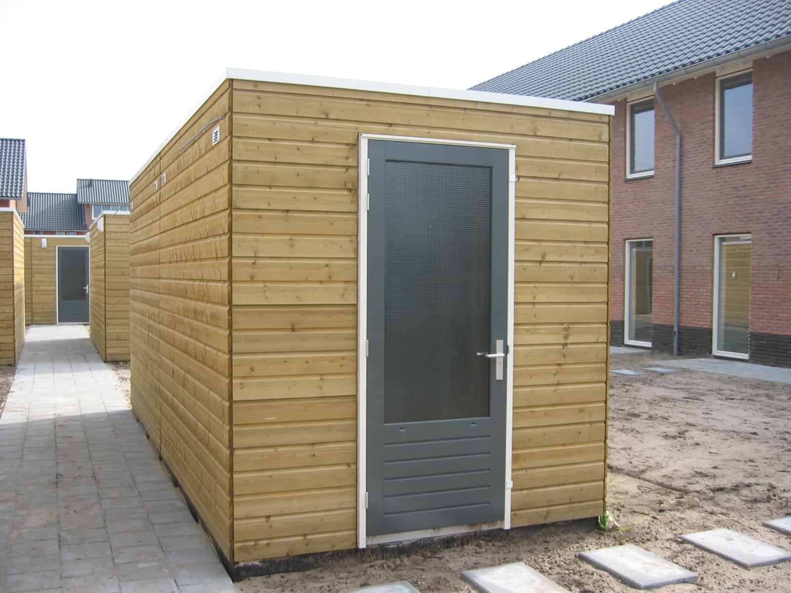 Berging lichte houtkleur met zwarte deur in stenen achtertuin
