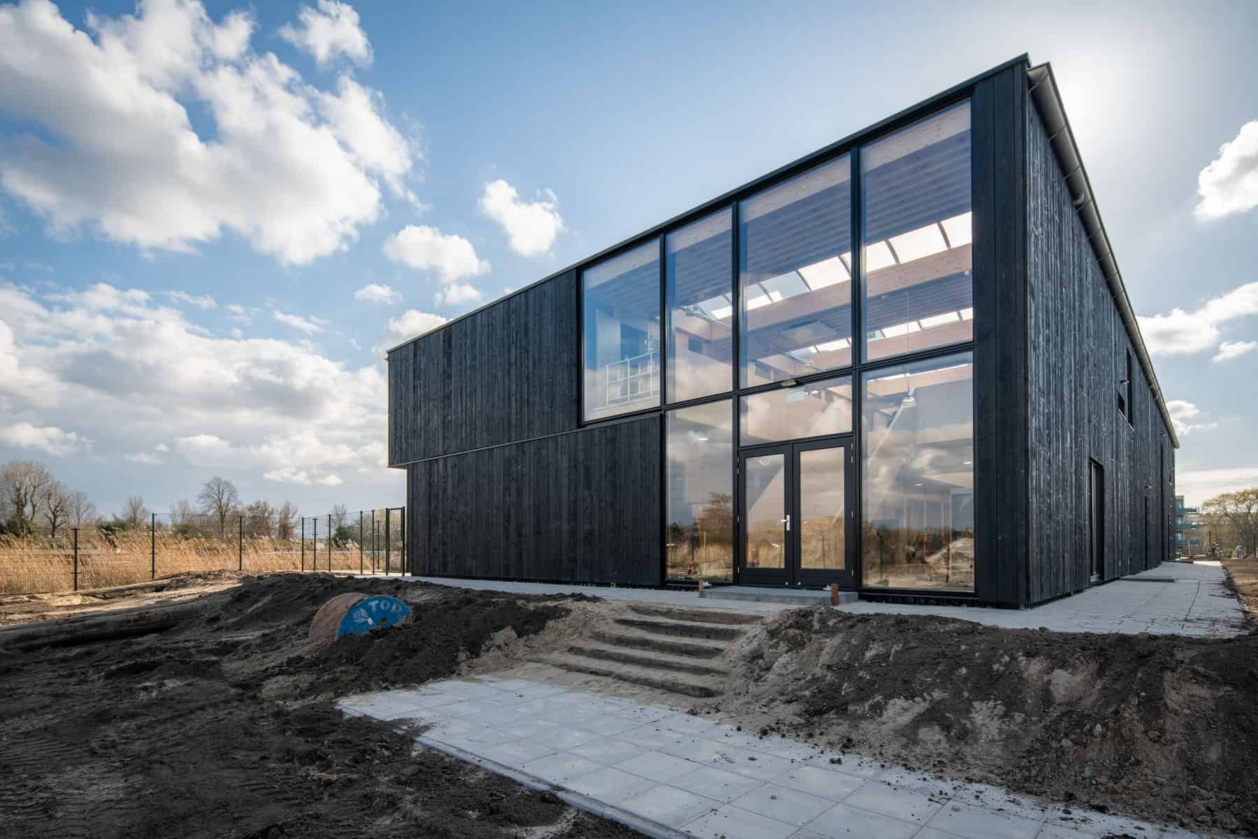 Zij-aanzicht van Klein Amsterdam met zwart hout en grote ramen