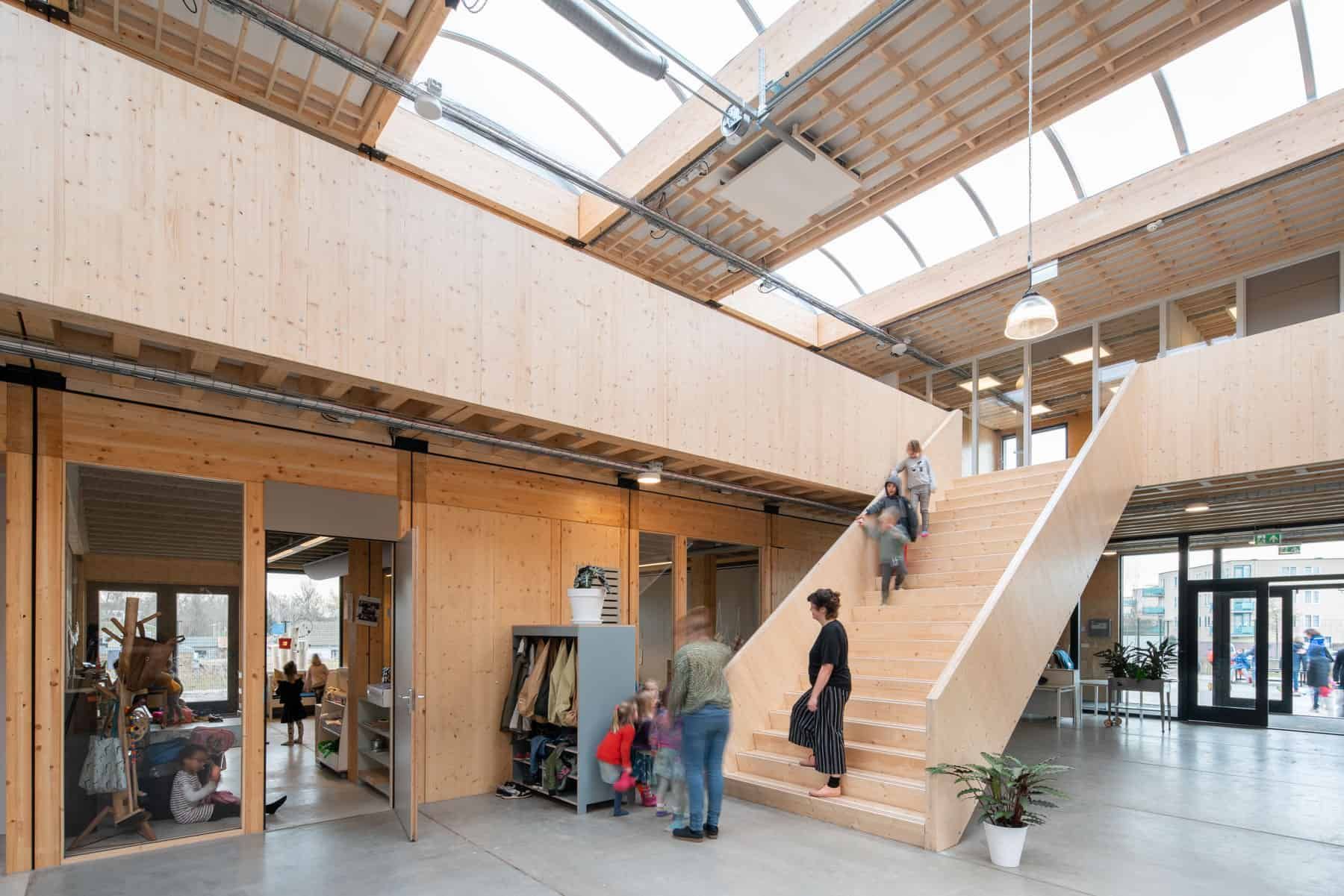 Basisschool Klein Amsterdam hal met houten trap en mensen