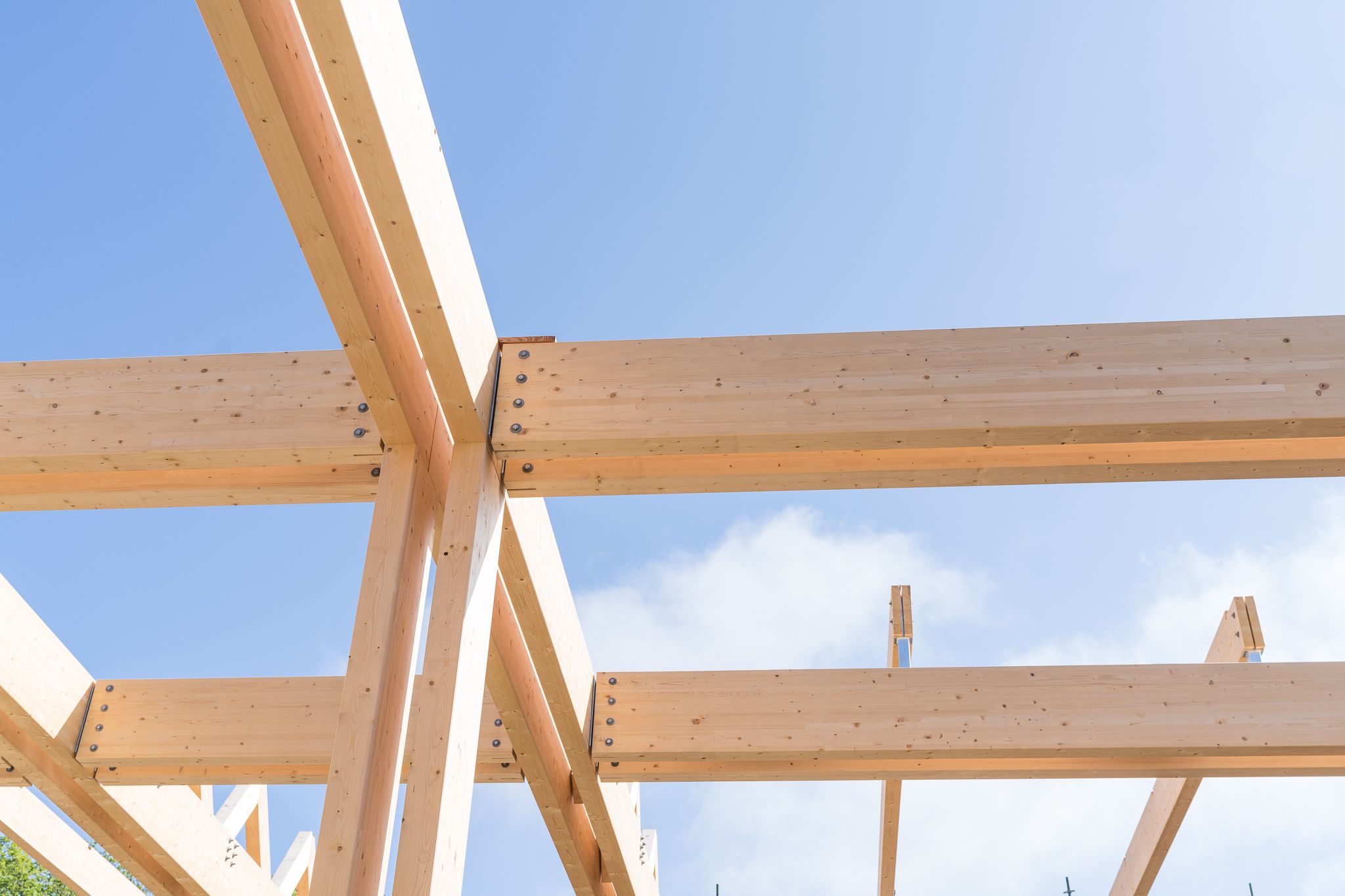 Constructie van houten balken van dichtbij met lucht erachter