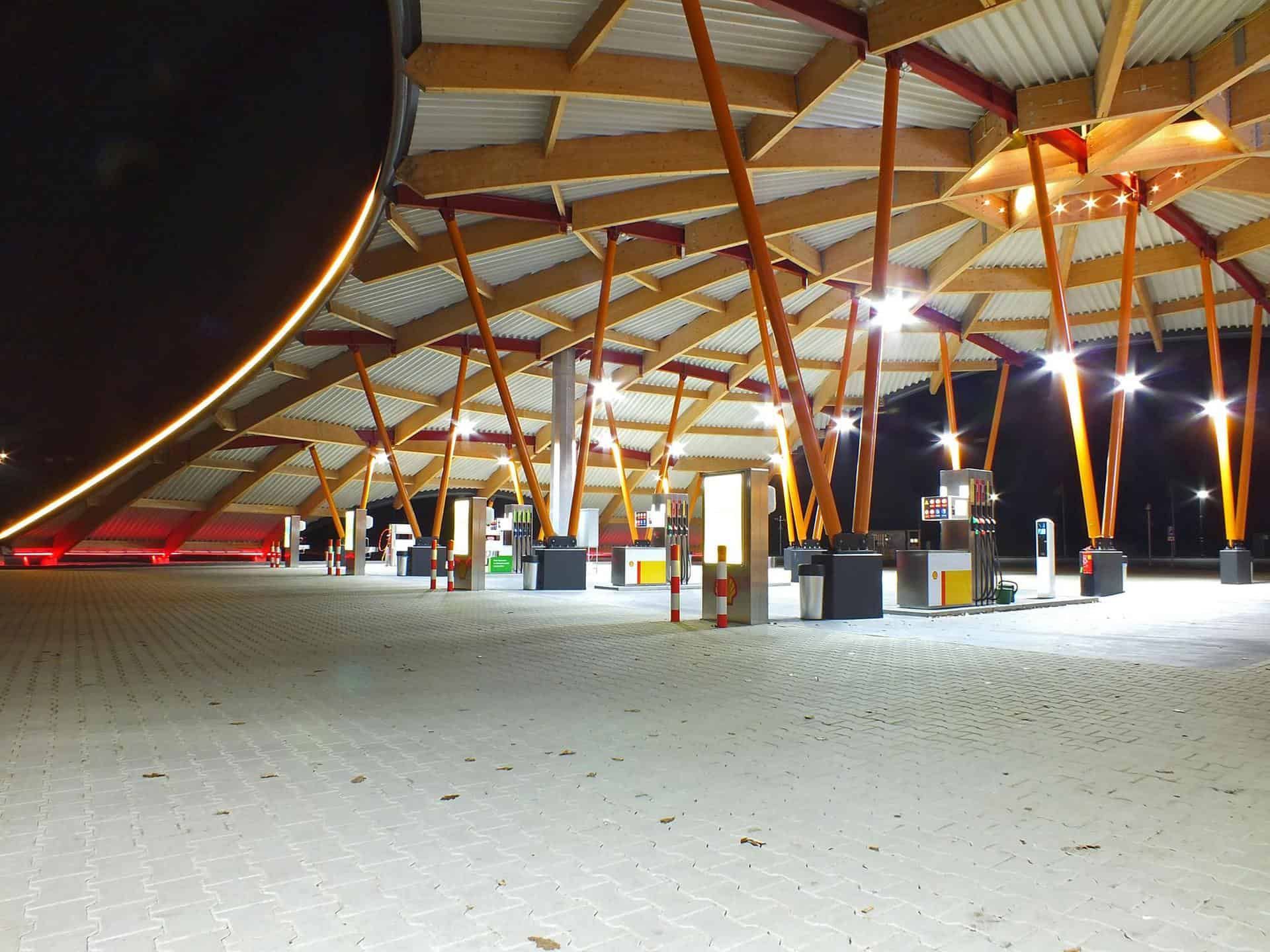 Een tankstation met houten palen in het donker