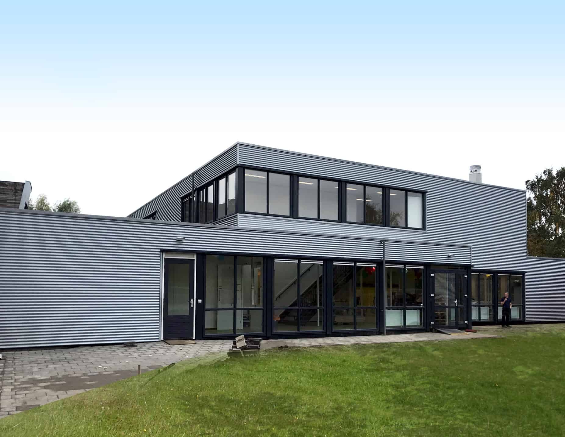 De grijze Helen Parkhurst school van buiten met zwarte kozijnen