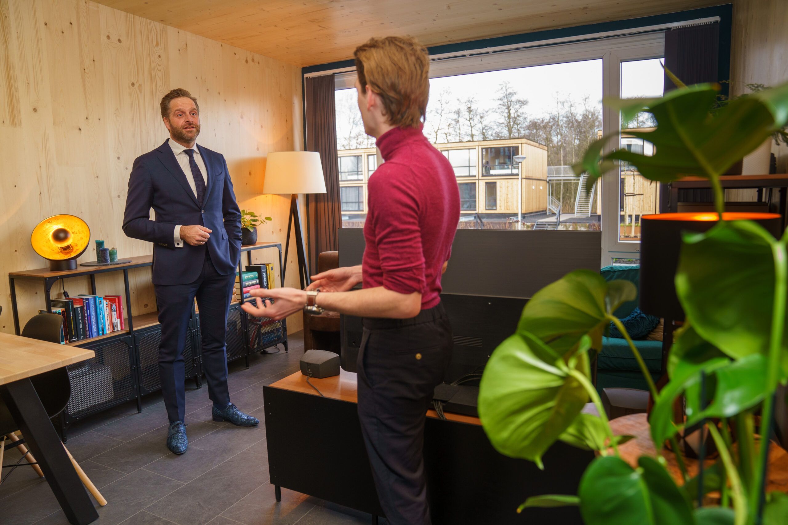 Hugo de Jonge in een kamer van hout met iemand in gesprek