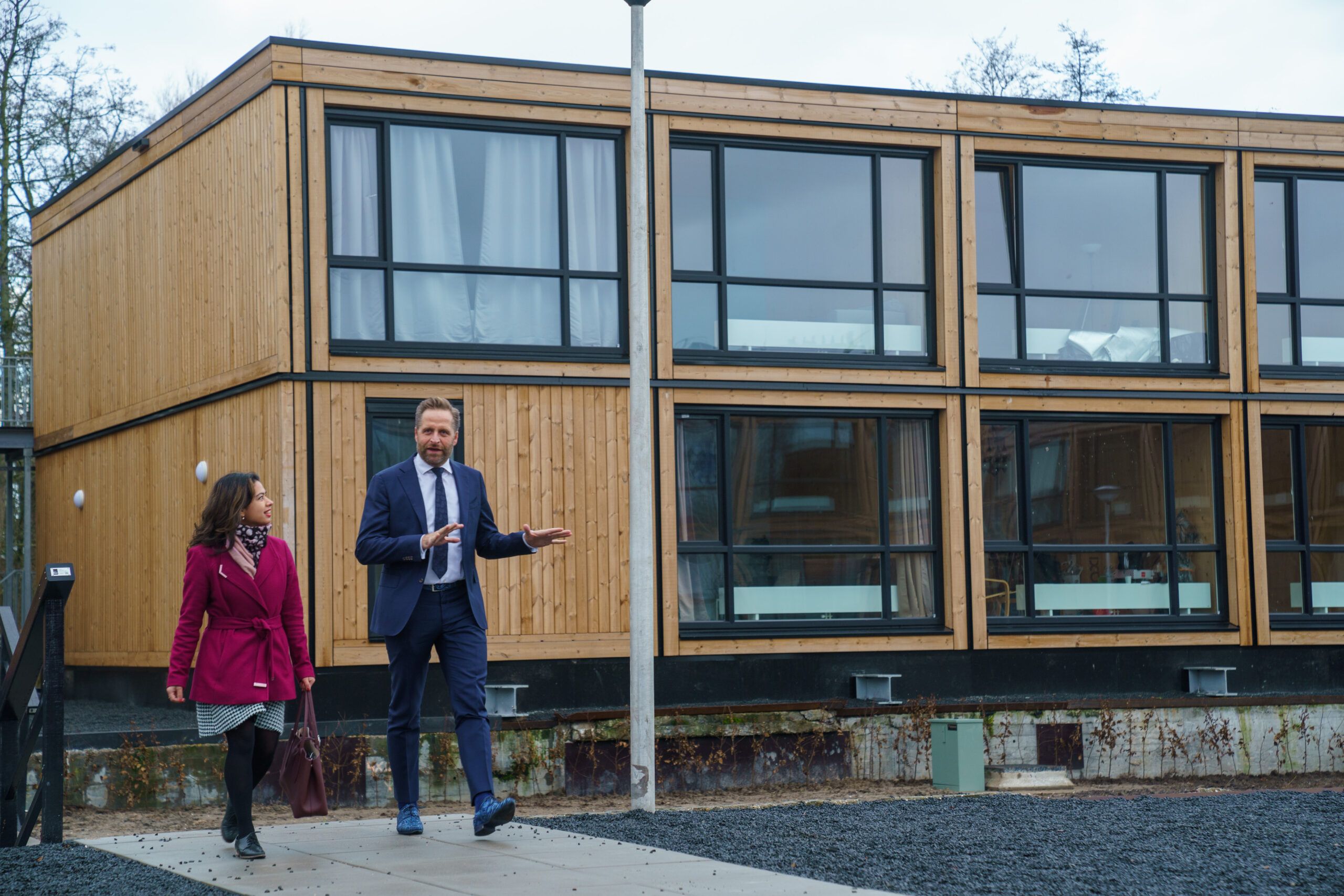 Hugo de Jonge in gesprek met met een vrouw buiten lopend voor een houten gebouw