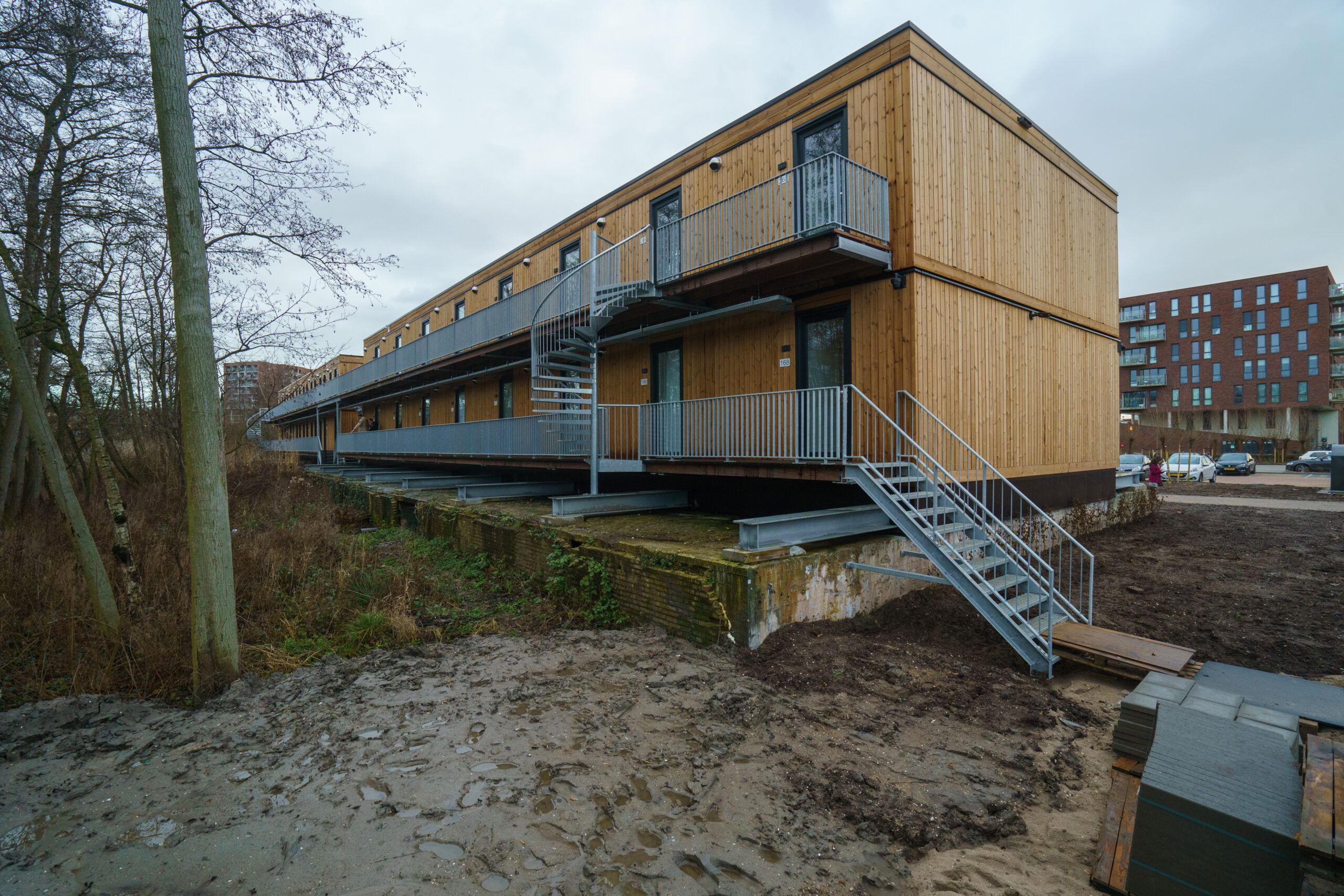 Houten gebouw met twee verdiepingen en een trap aan de buitenkant