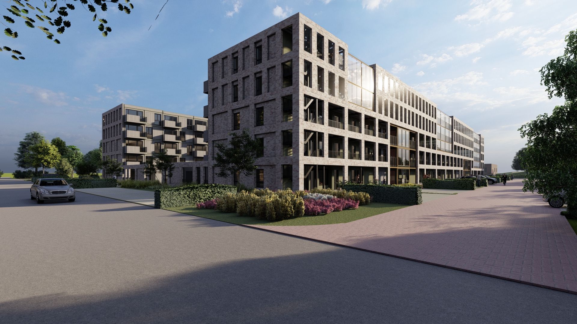 Grijs gebouw met planten en bosjes ervoor, veel glas en balkons