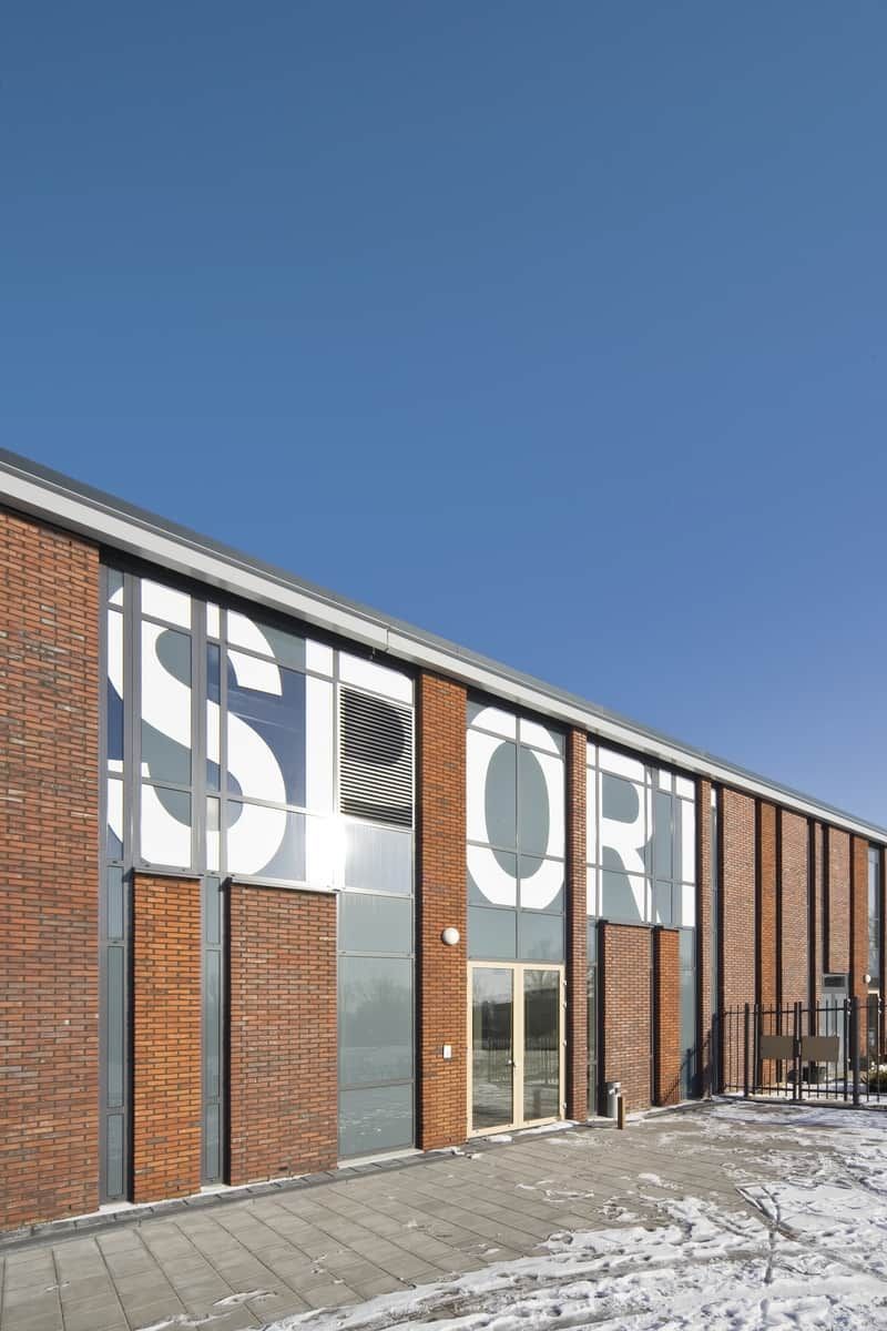 Ingang van sporthal van Koningin Emma school met grote witte letters