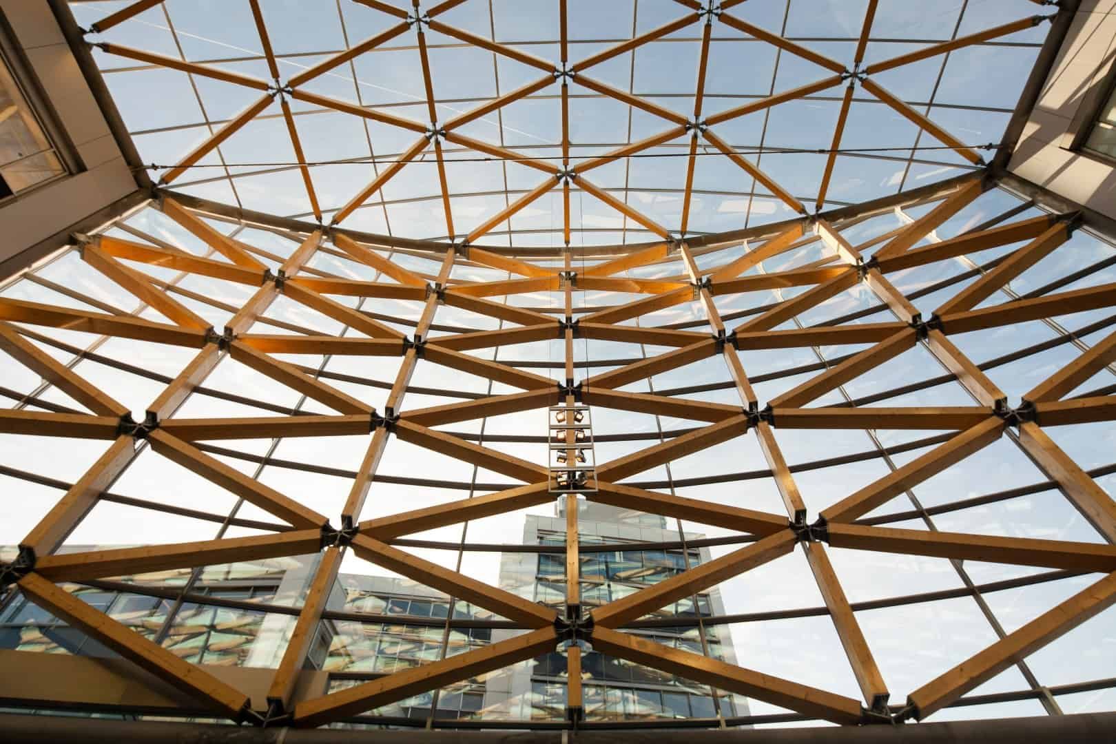 Glazen gebouw met houten balken aan de wanden en op het dak