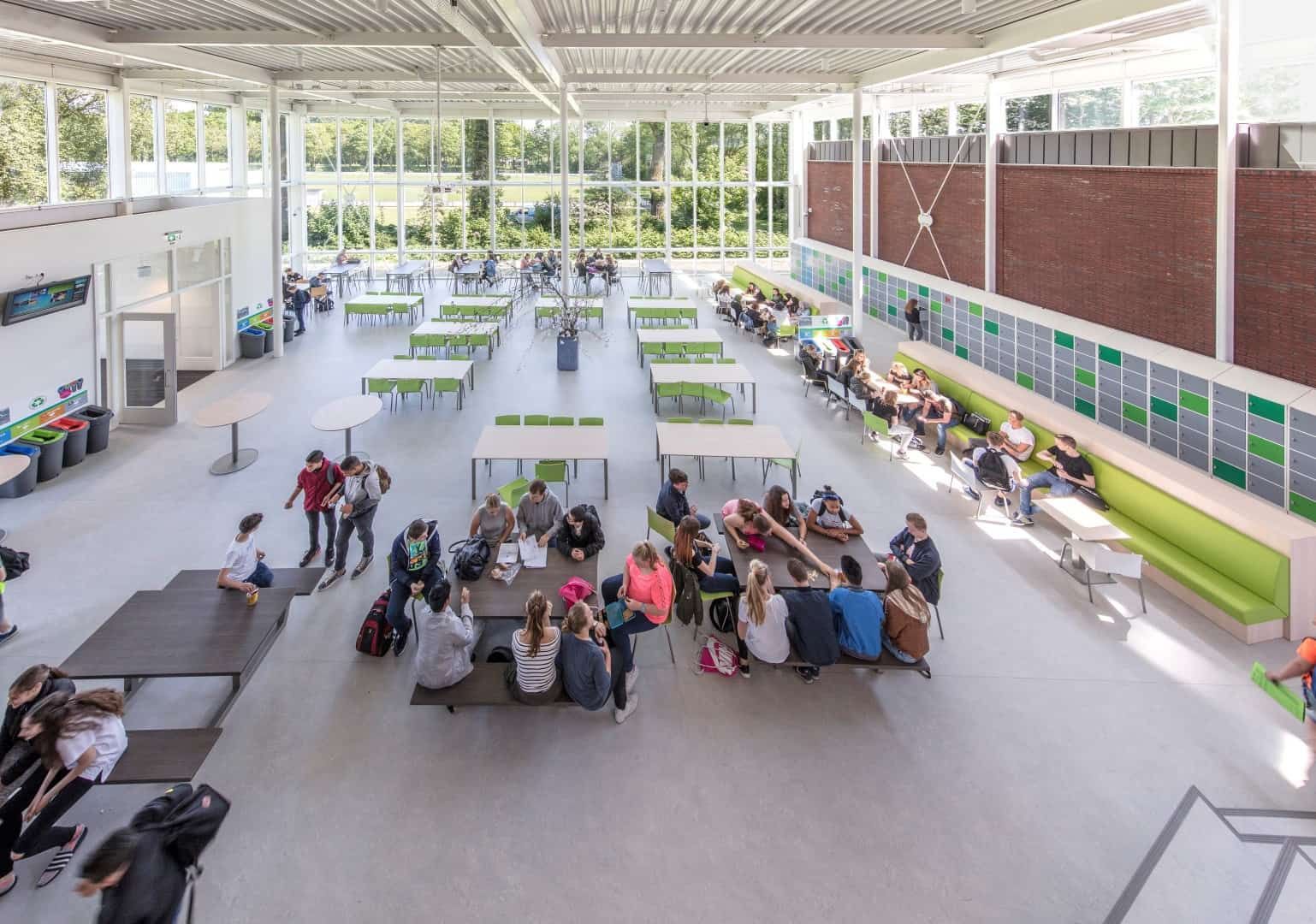 De kantine van boven met groene stoelen en leerlingen van het Wellantcollege