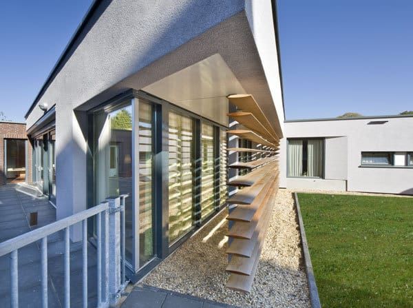 De hoek van het witte bungalowcomplex De Beemden met houten luxaflex, grind en gras