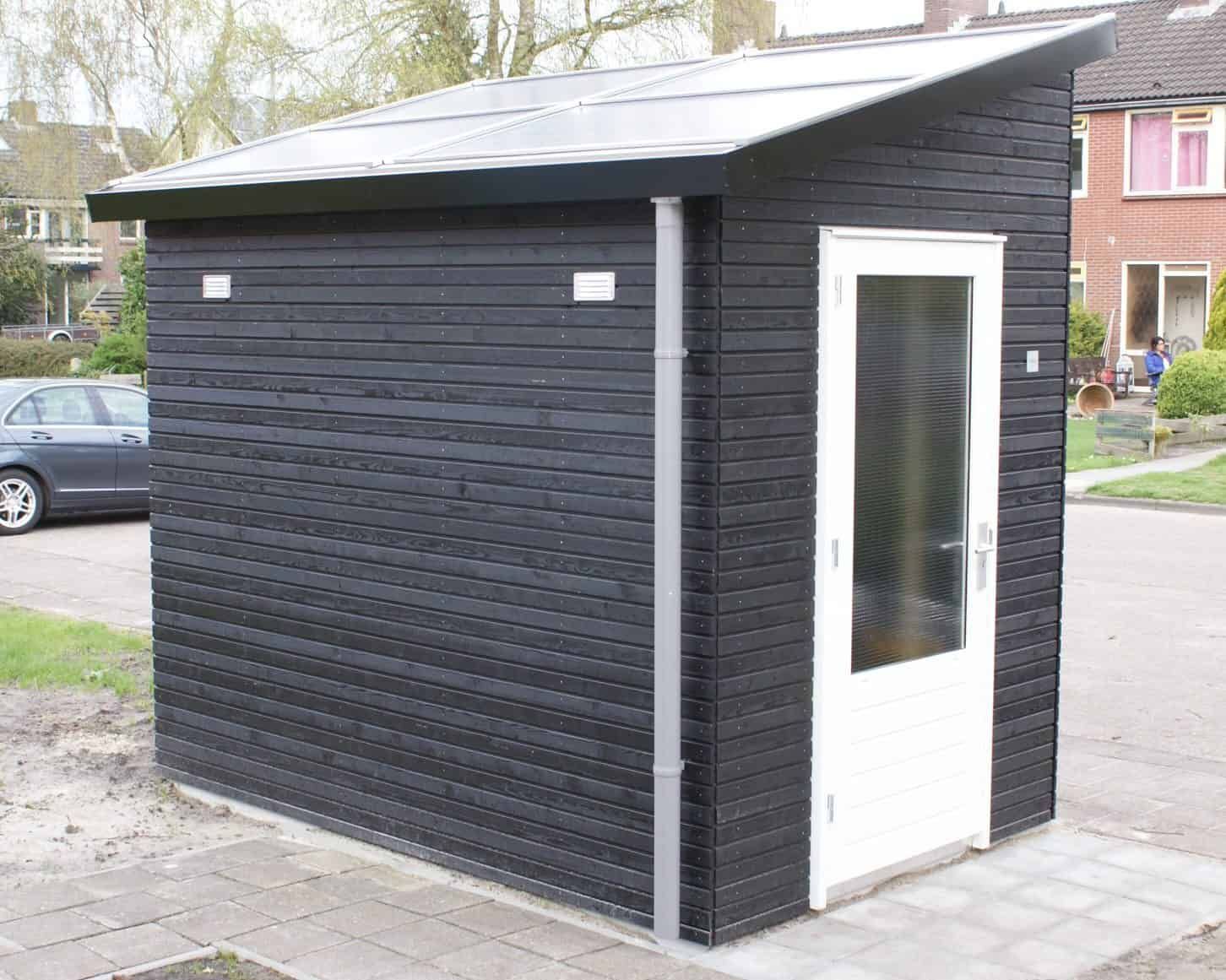 Zwarte kleine berging met zonnepanelendak