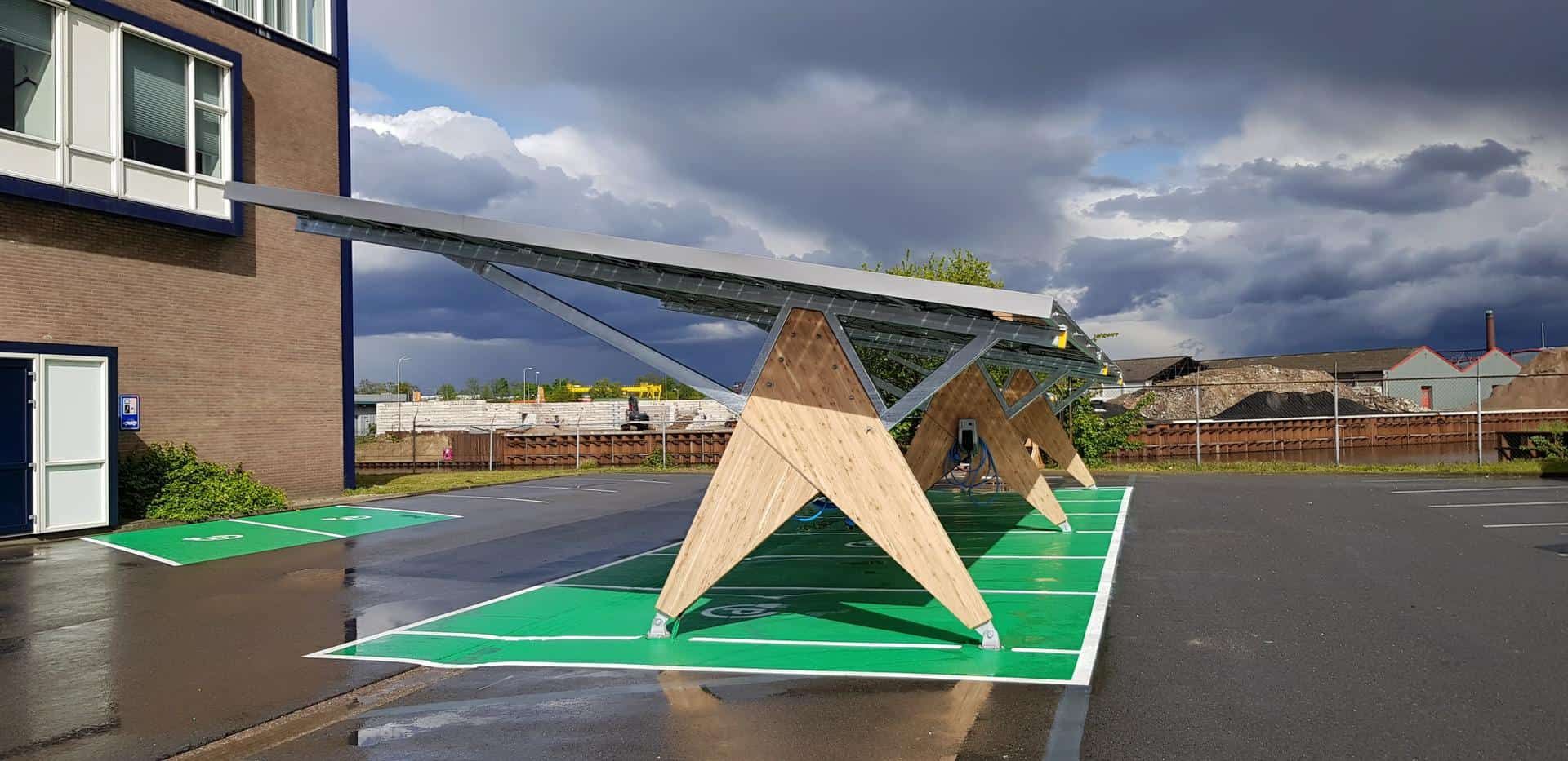 Een overkapping met houten constructie en zonnepanelen en groen asfalt