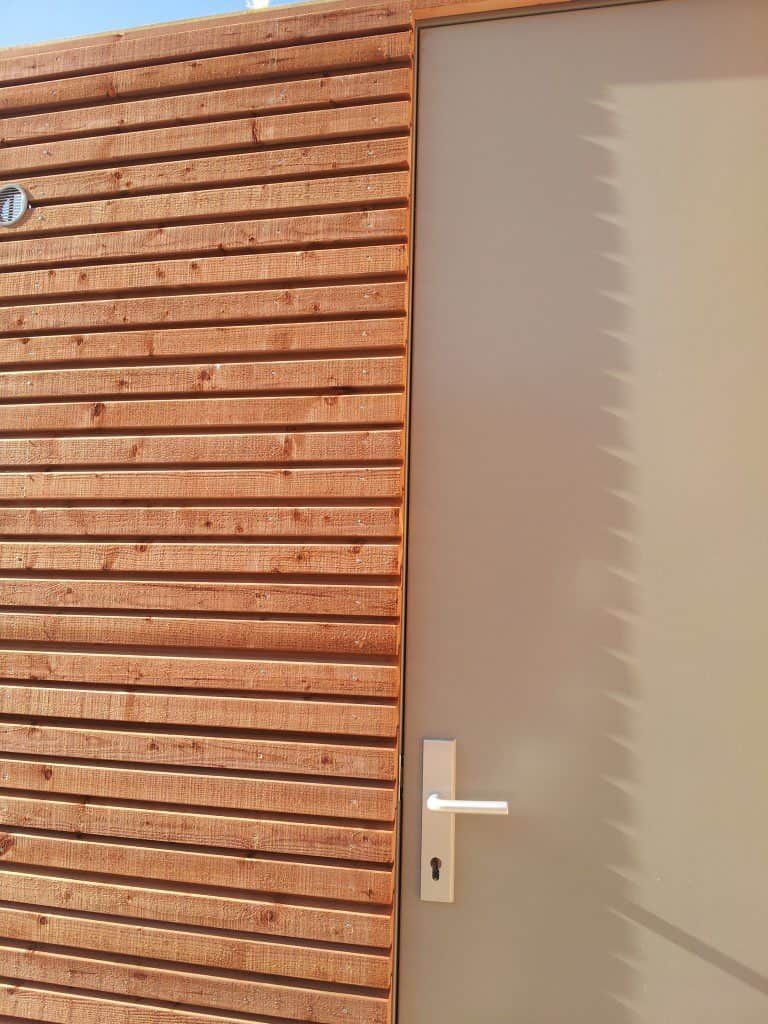 Houten wand met een bruine deur
