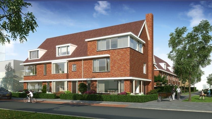 Een hoekhuis in een nieuwbouwwijk met groen en aan een weg