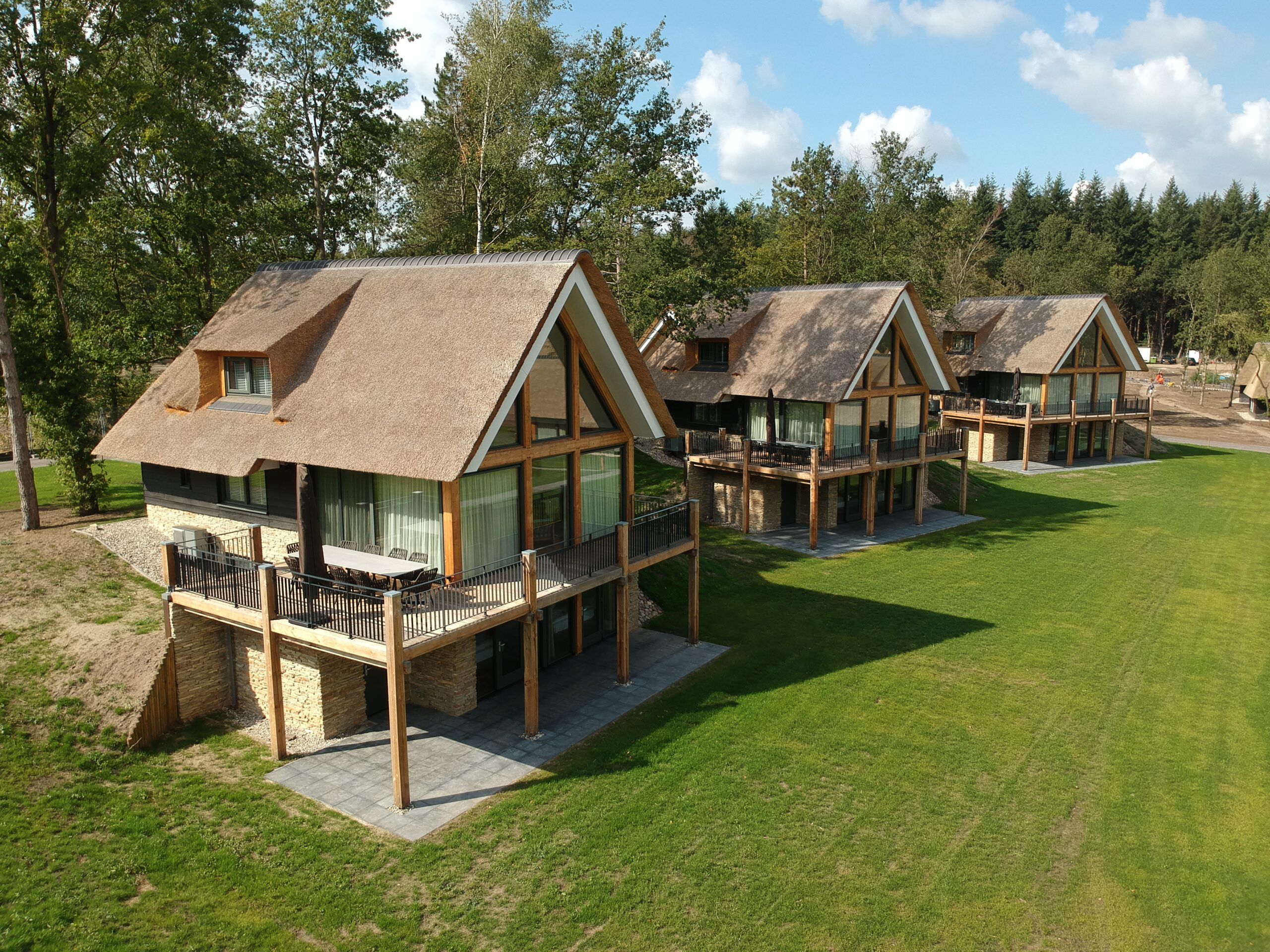 Huizen met rieten daken op een grasveld met een verlaging