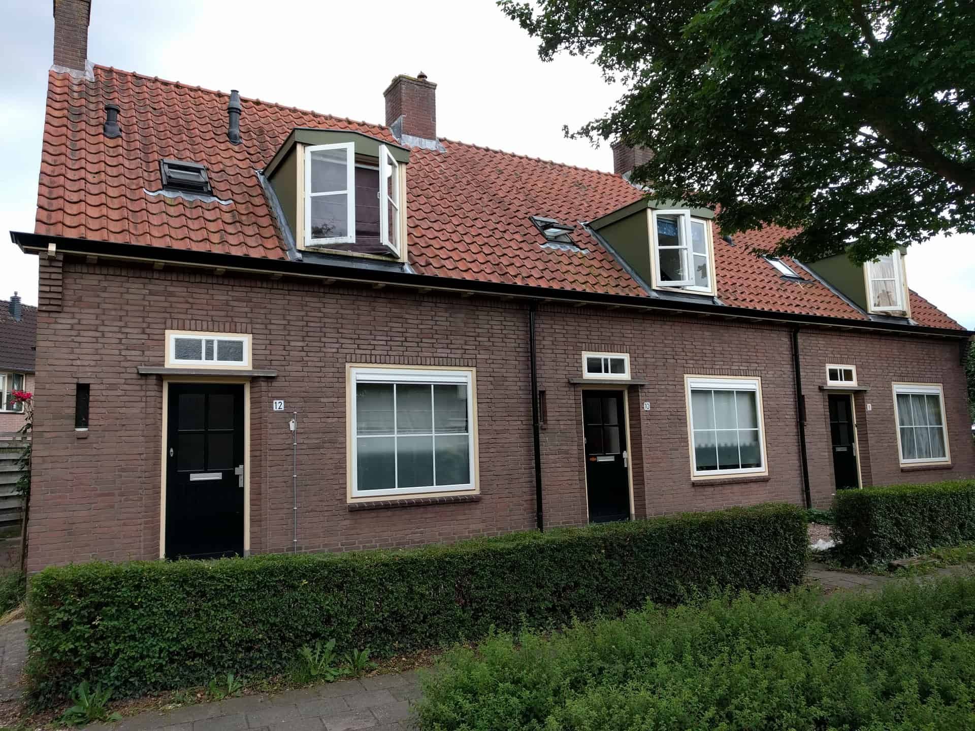 Rijtjeshuizen met dakkapellen met bosje ervoor