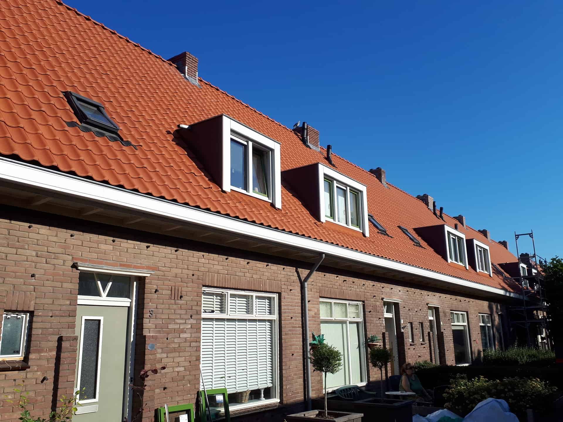 Rijtjeshuizen met dakkapellen en oranje dakpannen
