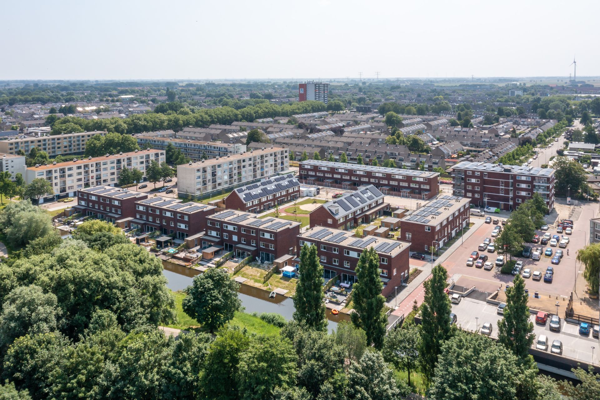 Woonwijk met rijtjeshuizen en appartementen aan het water met veel groen
