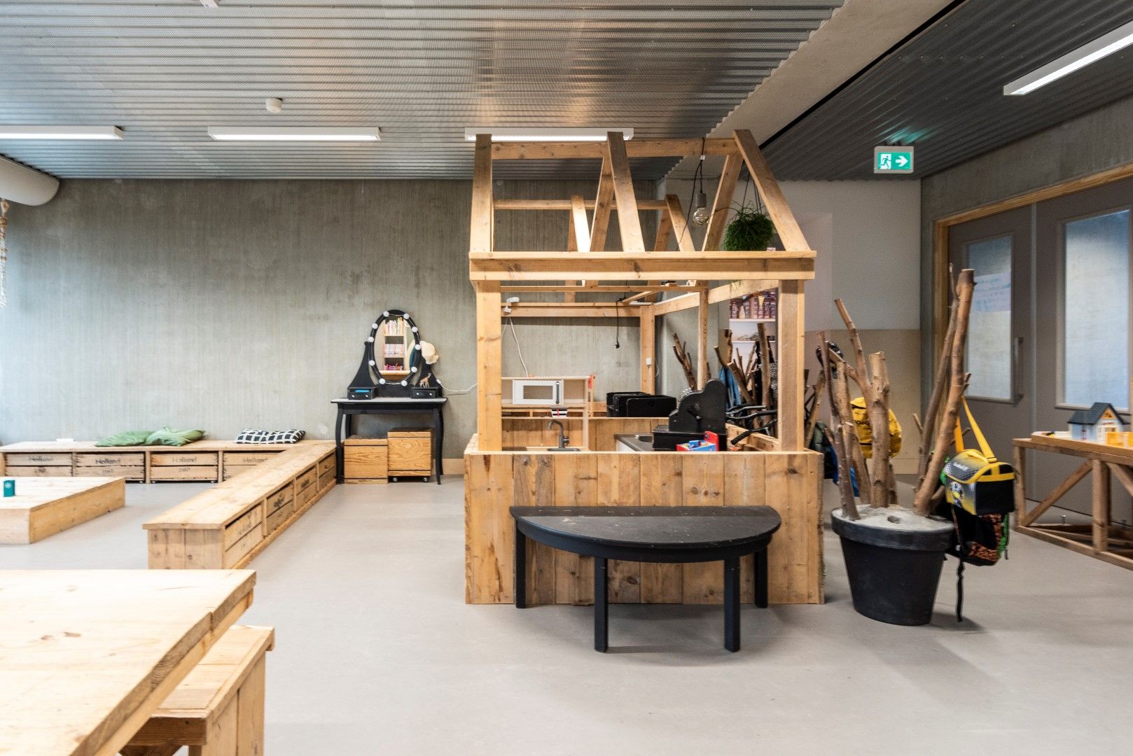 Houten speelhuisje binnen met houten opbergbakken en bankjes