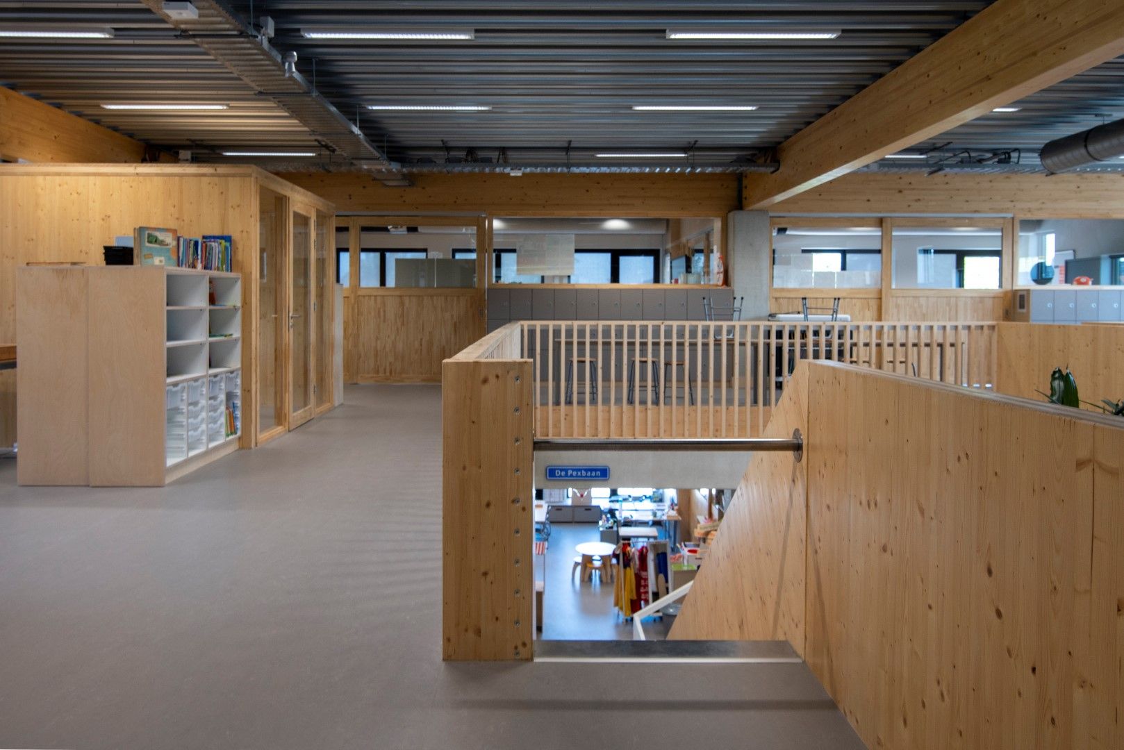 Bovenverdieping vanaf de glijbaan met houten kasten, houten wanden en houten balustrades
