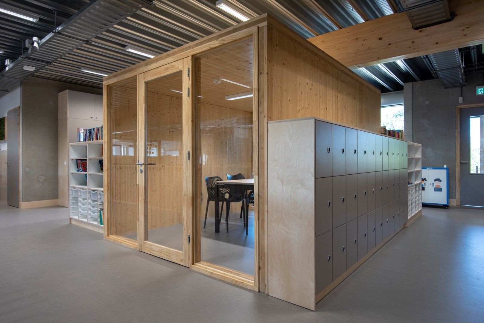 Houten hok waar je in kunt zitten met glazen ramen en een deur met aan de zijkanten houten opbergkasten
