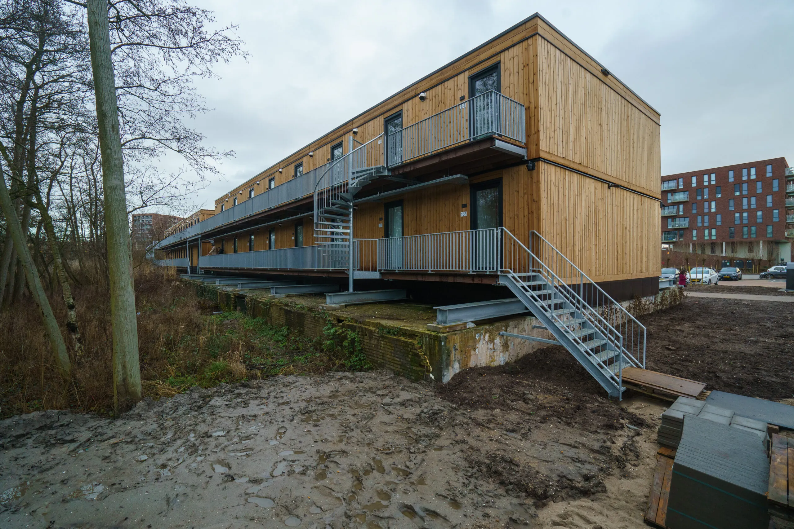 Houten gebouw met twee verdiepingen en een trap aan de buitenkant