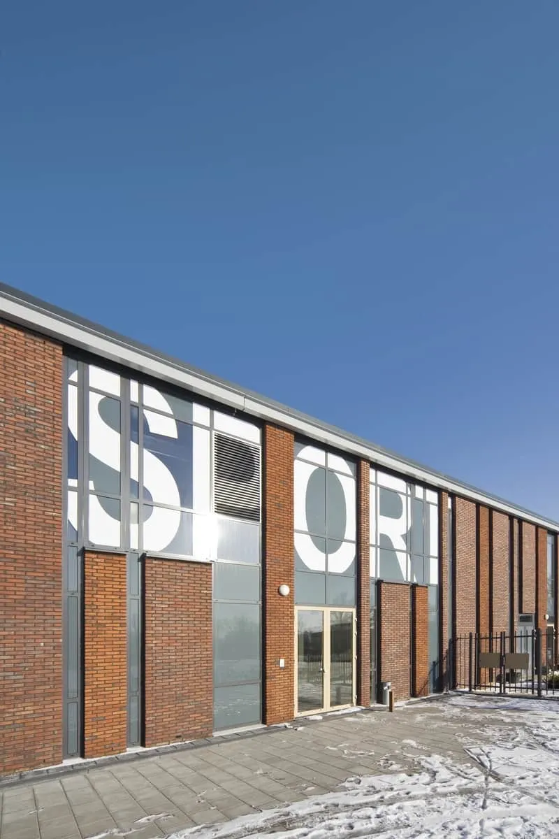 Ingang van sporthal van Koningin Emma school met grote witte letters
