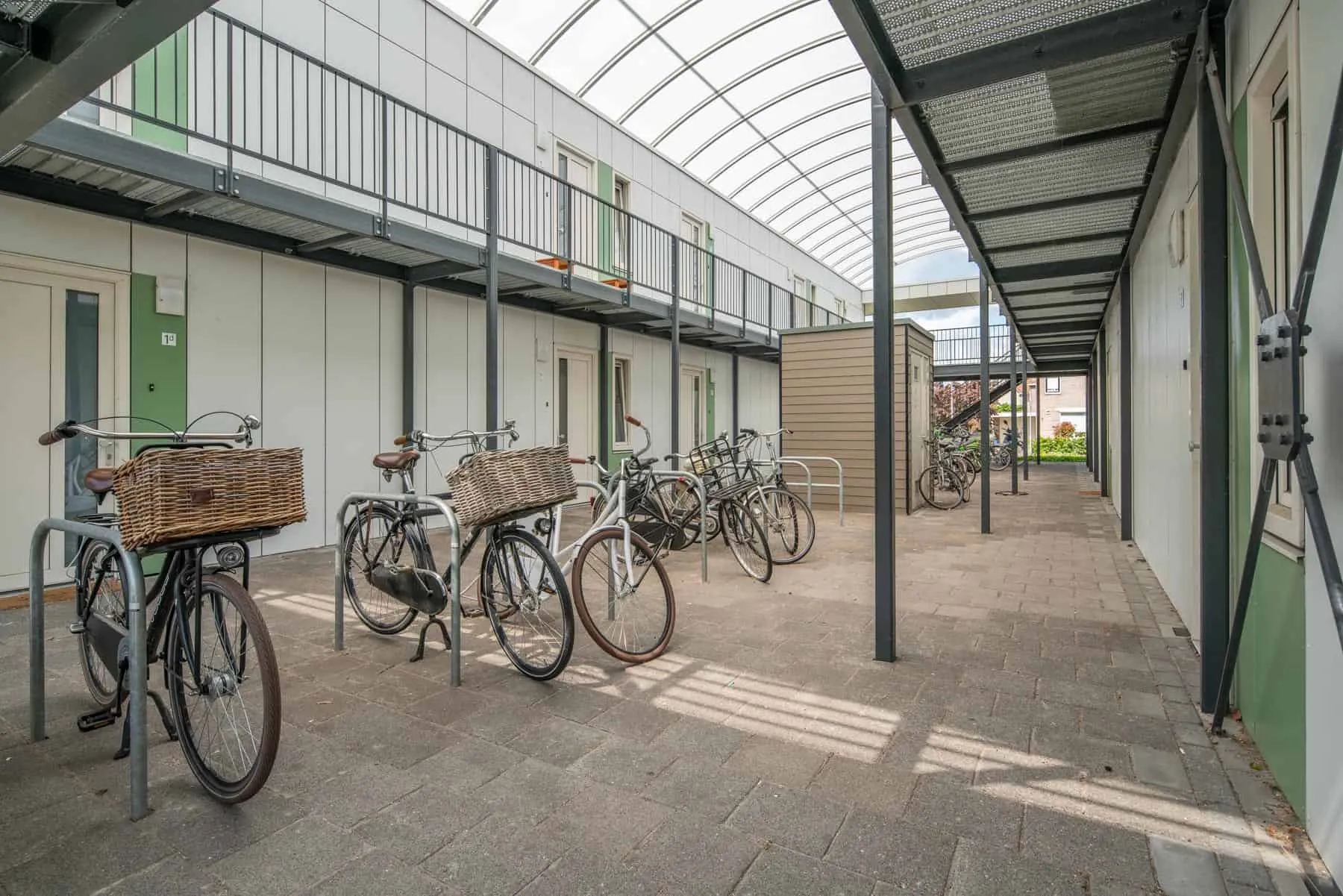 De overdekte binnenplaats met fietsen van de semipermanente woningen in Drachten