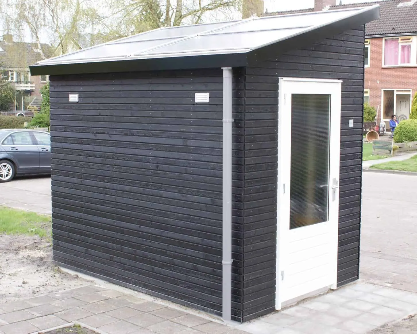 Zwarte kleine berging met zonnepanelendak