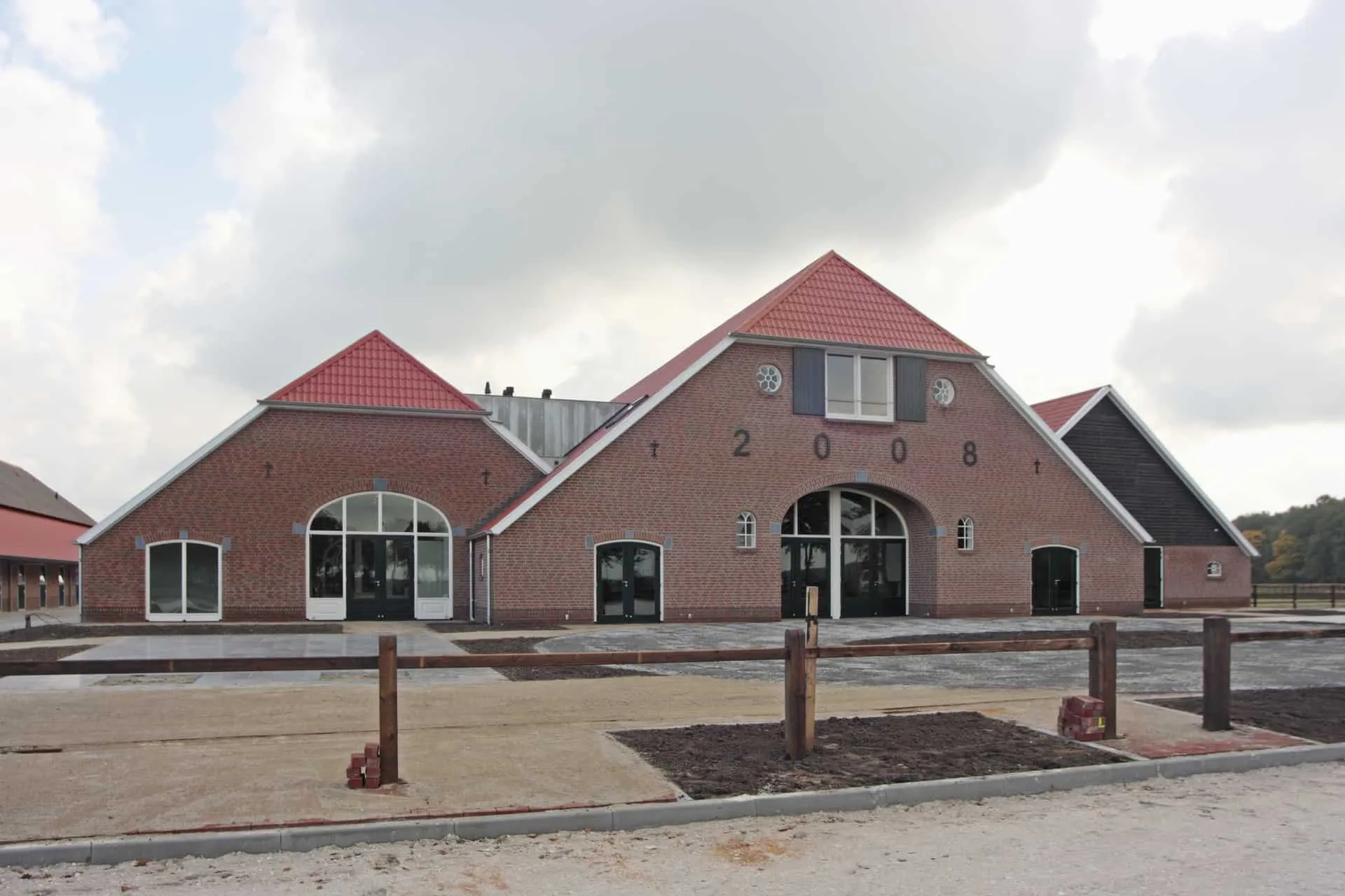 Stoeterij in stegeren met driehoek vormige luxe gebouwen met rijbak met wit zand
