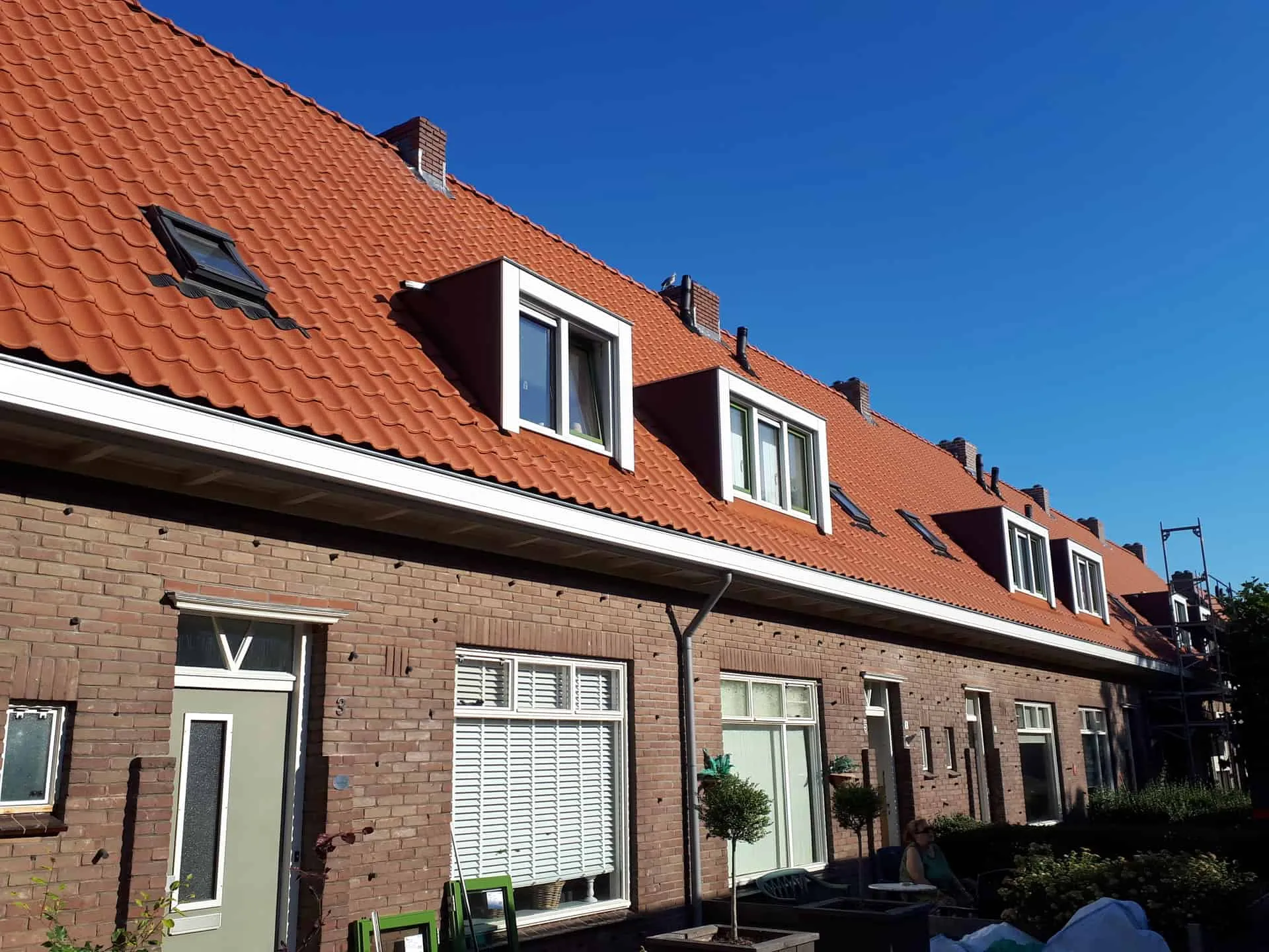 Rijtjeshuizen met dakkapellen en oranje dakpannen