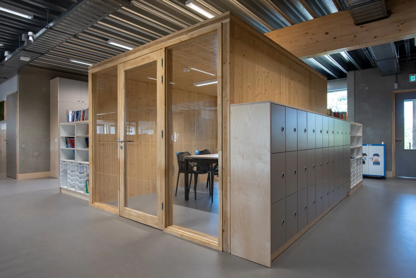 Houten hok waar je in kunt zitten met glazen ramen en een deur met aan de zijkanten houten opbergkasten