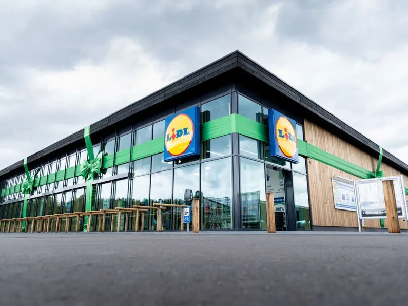 Glazen supermarkt met een houten wand en logo van de Lidl