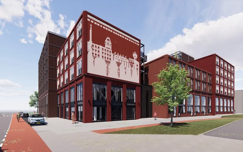Rood gebouw met veel ramen en een kunstwerk op de buitenmuur met grasstrook en een boom ervoor