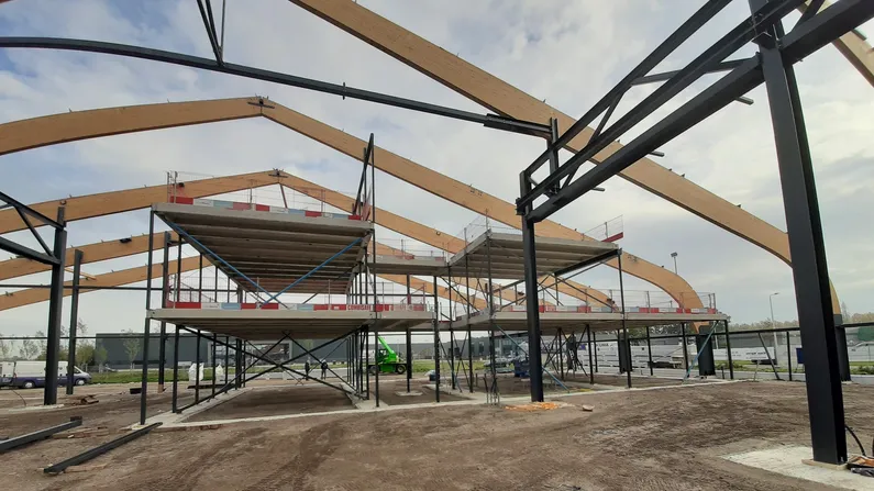 Houten spanten met stalen palen van een gebouw in aanbouw