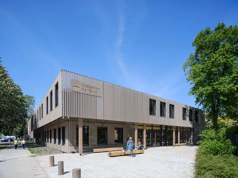 De voorkant en plein van het houten gebouw van Het Epos