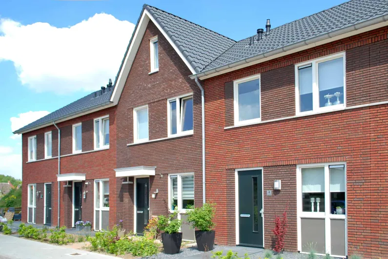 Rood nieuwbouwhuis met ramen en blauwe lucht met enkele wolken