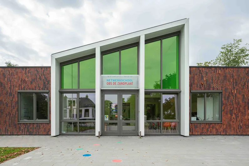 De ingang met schuin dak en groene kleur van basisschool In 't Zandt