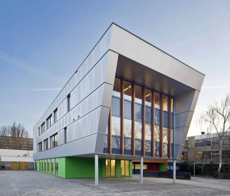Het grijze schuine gebouw met een groene onderkant en veel ramen aan de voorkant van CSG Dingstede