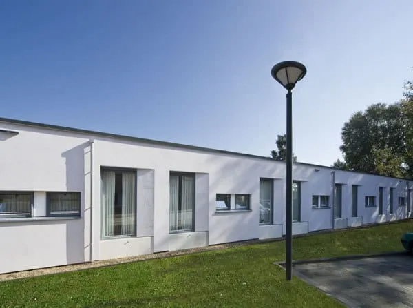 Het witte bungalowgebouw van woonzorgcentrum De Beemden met gras