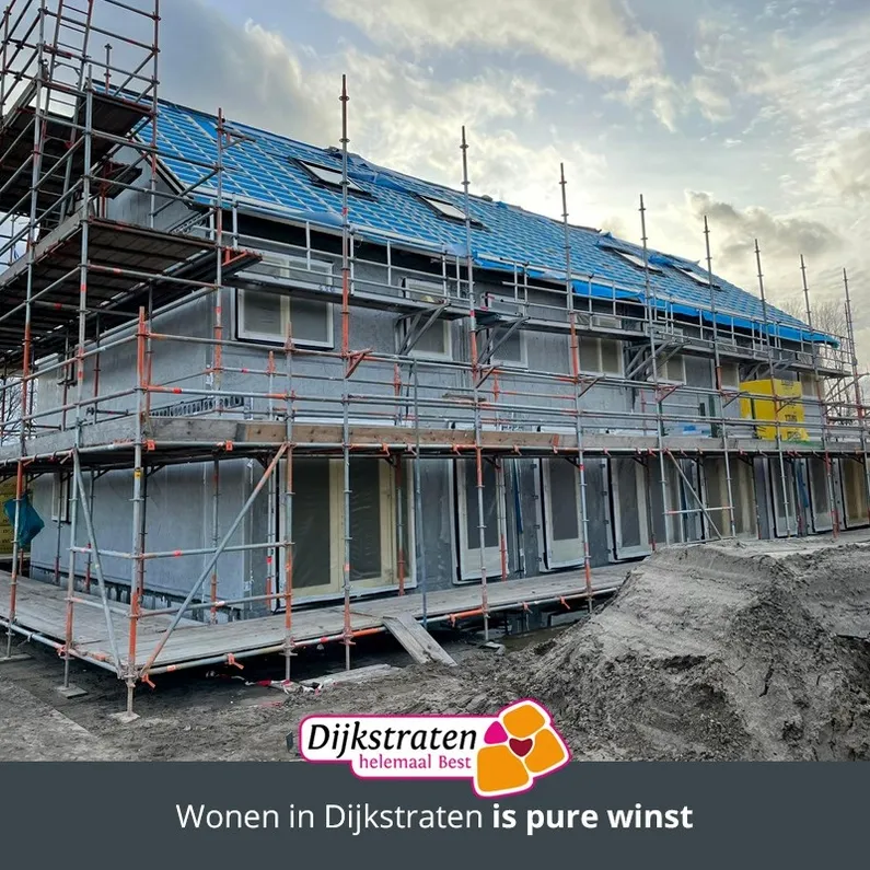 Een huis in aanbouw met steigers om de woning heen