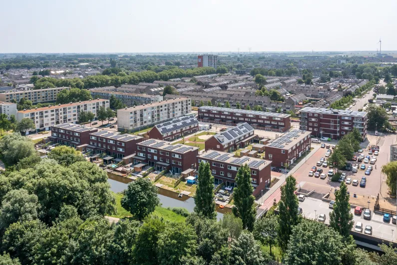 Woonwijk met rijtjeshuizen en appartementen aan het water met veel groen