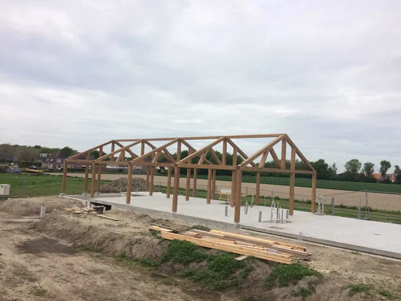 Houten constructie van gebouw in aanbouw in weiland